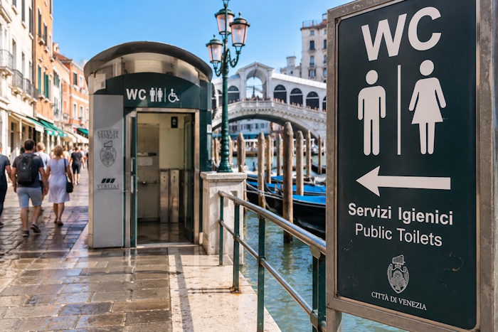 Öffentliche Toiletten in Venedig: WC-Anlage und Hinweisschild am Kanal